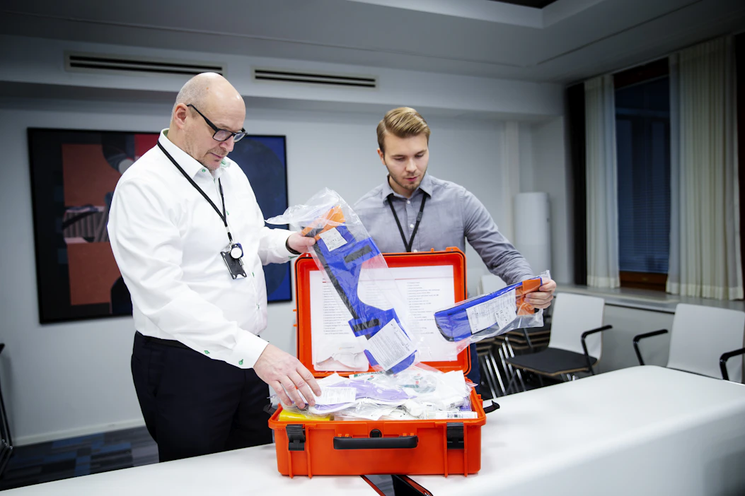 Huoltovarmuuskeskus (HVK) huolehtii muun muassa siitä, että Suomessa on poikkeustilanteiden varalta riittävästi esimerkiksi terveydenhuoltomateriaaleja. Mikko Matikkala ja Matti Mattila tutkivat sidetarvelaatikkoa.
