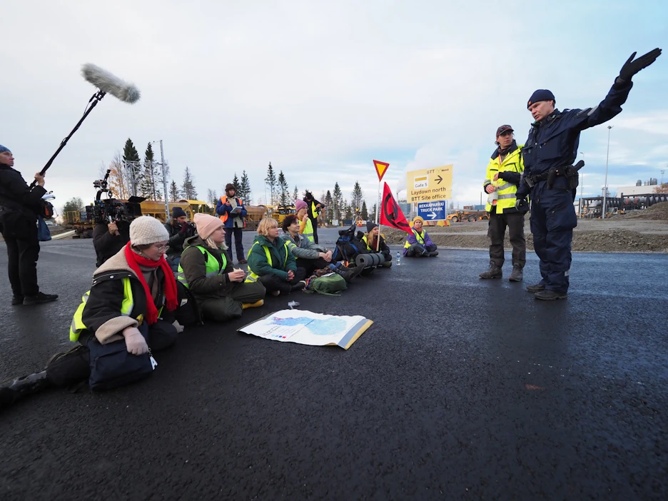 Elokapinan mielenosoittajat estävät liikenteen kulun Kemin Sahansaarentiellä. Tiellä on juliste, joka esittä Suomen metsien ikäjakaumaa.