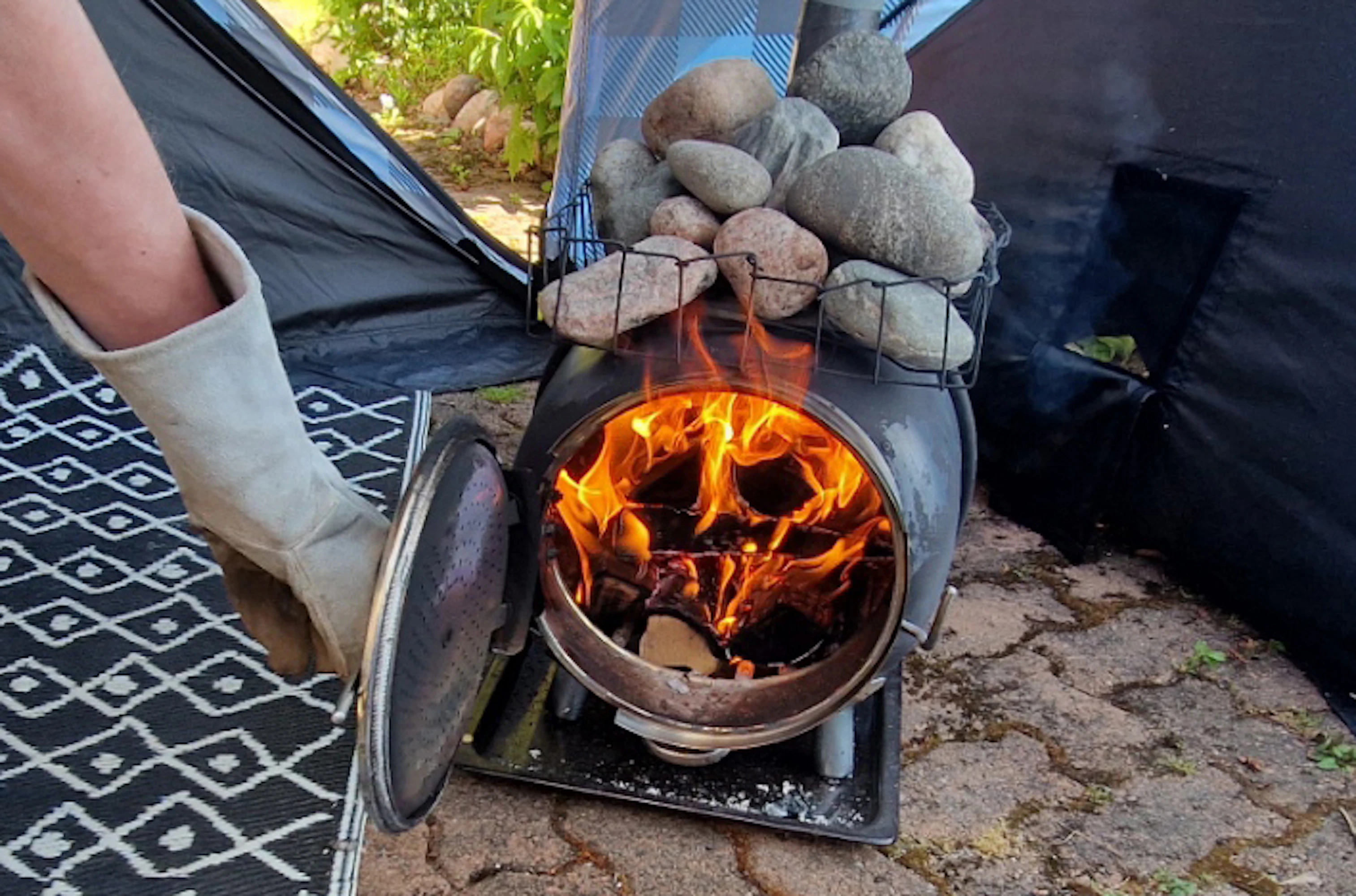 Telttasauna lämpenee yhdellä pesällisellä löylykuntoon. Luukku ja aukon kaulus ovat mehumaijasta peräisin.