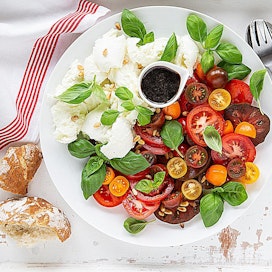 Yksinkertainen tomaatti-mozzarellasalaatti, caprese, tarjotaan Italiassa yleensä aterian alkupalana, mutta se maistuu myös ruokaisana lisäkkeenä.