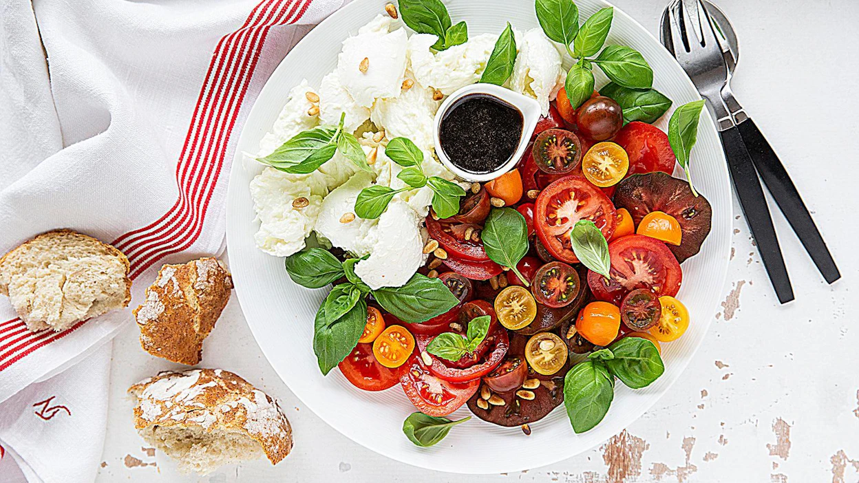 Yksinkertainen tomaatti-mozzarellasalaatti, caprese, tarjotaan Italiassa yleensä aterian alkupalana, mutta se maistuu myös ruokaisana lisäkkeenä.