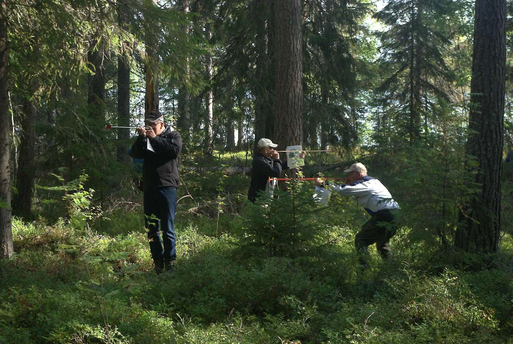 Metsätaitokisa mittaa metsänomistajien taitoja monipuolisesti. Kuvassa metsänomistajat arvioivat koealan puuston pohjapinta-alaa relaskoopeilla.