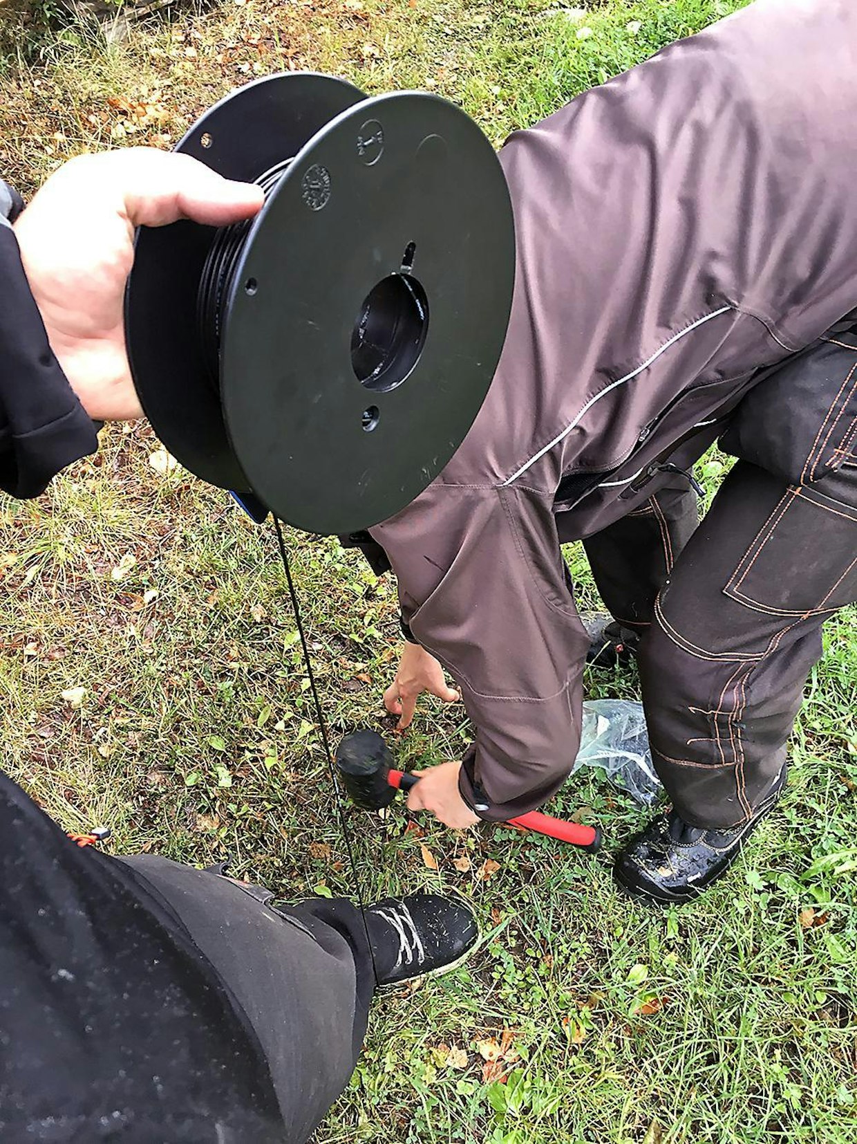 Testin rajalangat asennettiin kahden asentajan partiossa. Parhaiten asennus sujui, kun toinen veti lankaa edellä ja pingotti sen kuvan osoittamalla tavalla työkengän alitse, ja toinen naulasi langan kiinnikkeillä kiinni maahan.