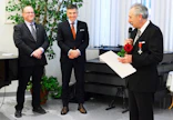 Jouni Jyrinki nauratti kiitospuheessaan kokousväkeä toteamalla, että näyttämöltä pitää poistua ja puhe lopettaa silloin, kun yleisö vielä taputtaa. Vasemmalla myhäilee MTK-Keski-Pohjanmaan johtokunnan varapuheenjohtaja Vesa Isolankila, jonka vieressä on MTK:n puheenjohtaja Juha Marttila. Marttila luovutti Jyringille Suomen Leijonan ritarikunnan ritarimerkin.