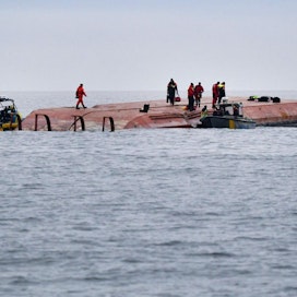 Pelastushenkilöstöä työskenteli kaatuneen Karin Höj -aluksen päällä maanantaina. LEHTIKUVA / AFP