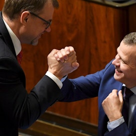 Pääministeri Juha Sipilä ja valtiovarainministeri Petteri Orpo löivät kättä eduskunnassa.