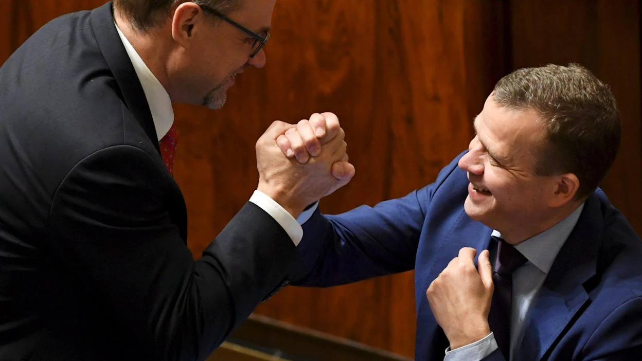 Pääministeri Juha Sipilä ja valtiovarainministeri Petteri Orpo löivät kättä eduskunnassa.