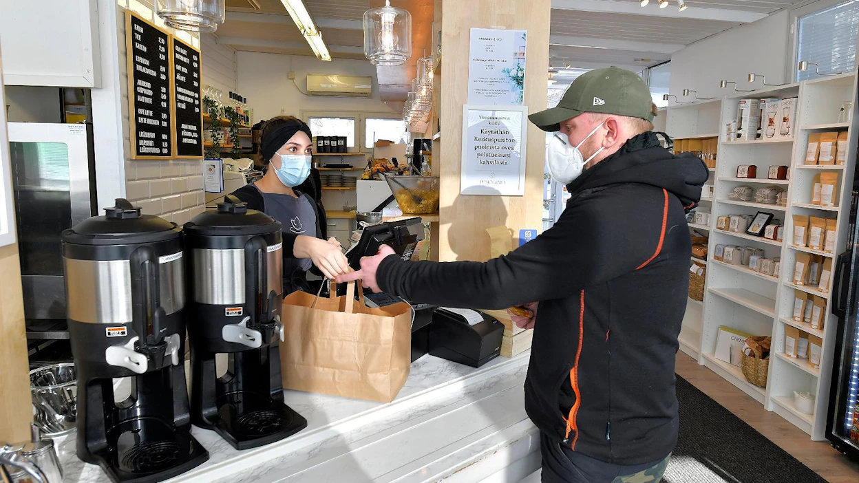 Ismo Virtanen osti mukaansa take away -lounaspaketin Venla Pietsalolta Rauman Puistokahvilassa maanantaina. Satakunta on yksi 15 maakunnasta, joita ravintolasulku koskee.
