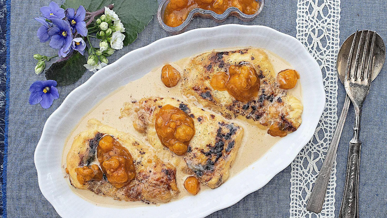 Ruskeapilkkuinen leipäjuusto pehmenee uunissa kahvilla maustetussa vaniljakastikkeessa. Lakat kruunaavat herkun.