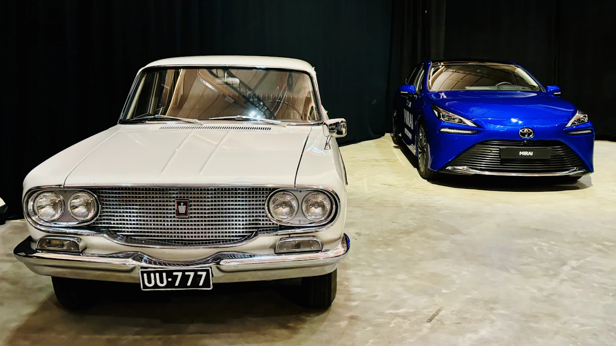Toyotan Suomen valloitus alkoi kuvan Crownilla, joka lennätettiin tänne esittelykäyttöön Japanista vuonna 1964. Sen sivulla komeilee Toyotan vedyllä kulkeva Mirai.