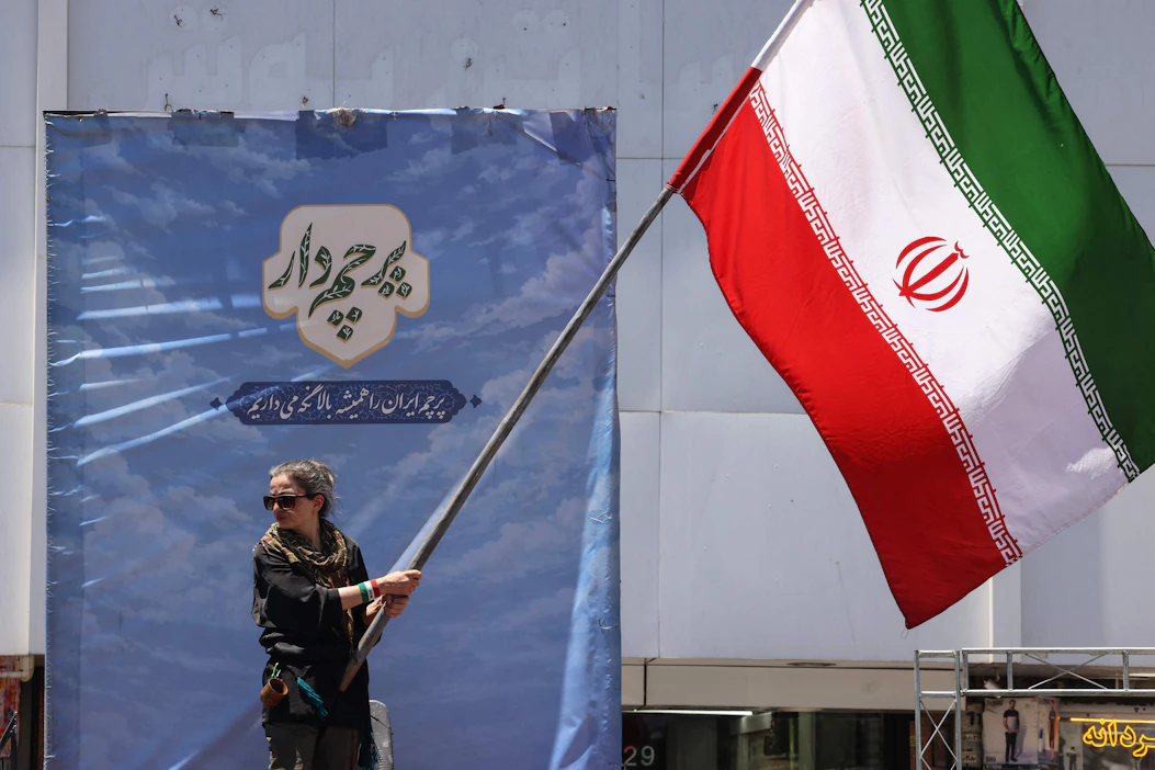 Iran on sanonut, että Yhdysvaltojen on varmistettava, että Israel lopettaa sotatoimensa myös Libanonissa. Iranilaisnainen liehutti maansa lippua Teheranissa maanantaina. AFP/LEHTIKUVA.