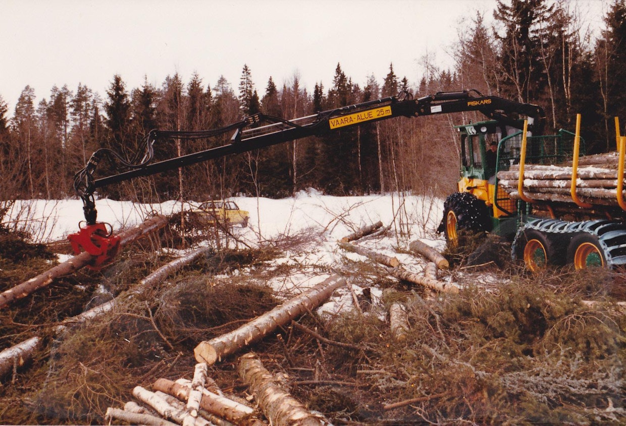 Kaksi aikakautensa vauhtihirmua samassa kuvassa, maineikas ralliautomalli Ford Escort MK2 ja Ponsse S15. Lahtisten ensimmäisessä S15:ssa oli alussa Fiskarsin kolmijatkeinen F50, joka vaihdettiin hyvin pian järeämpään F60-malliin. Kymmenen metrin ulottuma oli metsuripuiden ajossa suuri harppaus ja vähensi metsureiden työtaakkaa merkittävästi, sillä kasaaminen voitiin tehdä palstalle, eikä ajourien varteen.