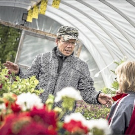 Reijo Oikarainen neuvoo asiakasta kukkien istutuksessa ja hoidossa. Juha Kauppinen