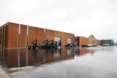 Rautapigmenttibetonilla verhoiltu Palmsin tehdas on vaatimattoman näköinen. Sen ovista kuitenkin lähtee vuosittain 1 700 nosturia ja 1 500 metsäperävaunua eri puolille maailmaa. Kaikki tuotteet valmistetaan tilauksesta, joten pihalla ei ole massiivisia varastoja.