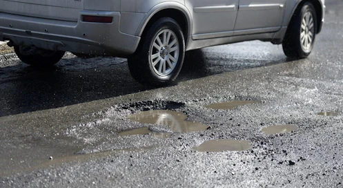 Miten paha kuoppa valtion maantiessä pitää olla, jotta autoilija olisi oikeutettu korvauksiin autolle syntyneistä vahingoista? LEHTIKUVA / HEIKKI SAUKKOMAA