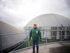 Viljelijä Michael Reber ”tehtaansa” eli biokaasureaktorin katolla. Termofiilisessä (plus 47–48 astetta) mädätysprosessissa kasvimassat ja karjanlanta muuntuvat biokaasuksi – metaanin ja hiilidioksidin seokseksi. Rejektit puolestaan korvaavat liki kaiken ostolannoitteen.