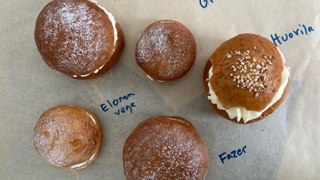 Pullat edessä vasemmalta Elosen "ujo vaalea vege" ja Fazerin tavallinen "sämpylä, jossa täyte piilossa", takana Truben "moni kakku päältä kaunis vege", Fazerin gluteeniton "kakkupulla" ja Huovilan "muhkea kermaunelma".