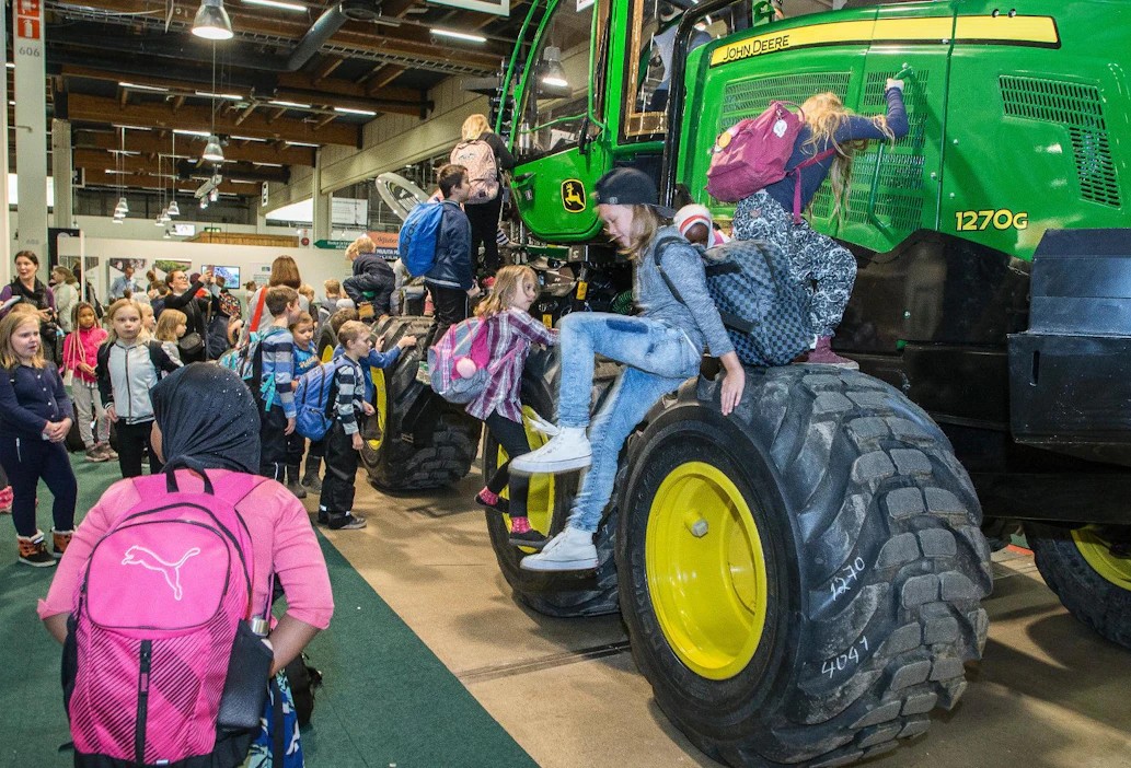 Jo messuklassikoksi muodostuneen Ponssen ajokoneen lisäksi messuhallista löytyi tänä vuonna John Deeren harvesteri. Kuvan kiipeilijät saapuivat messuile Helsingin Maatullin ala-asteen koulusta.