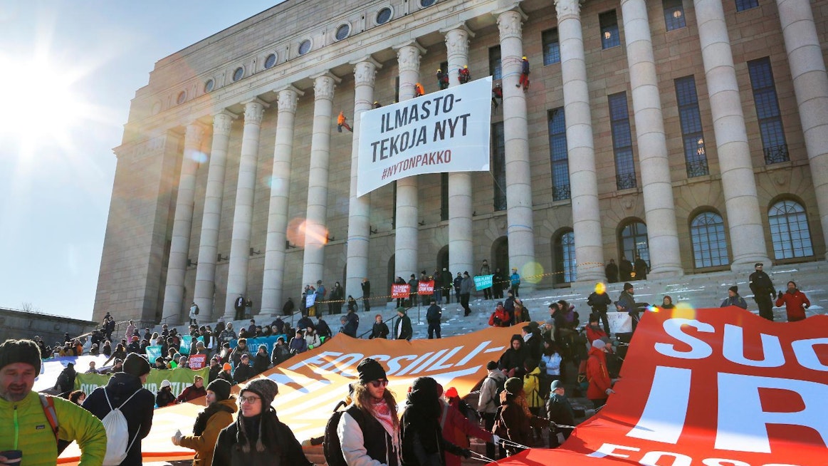 Greenpeacen aktiivit vaativat päättäjiltä ilmastotekoja 6.3. eduskuntatalolla. Järjestö ei ota rahaa vastaan julkisilta tahoilta ja yrityksiltä.