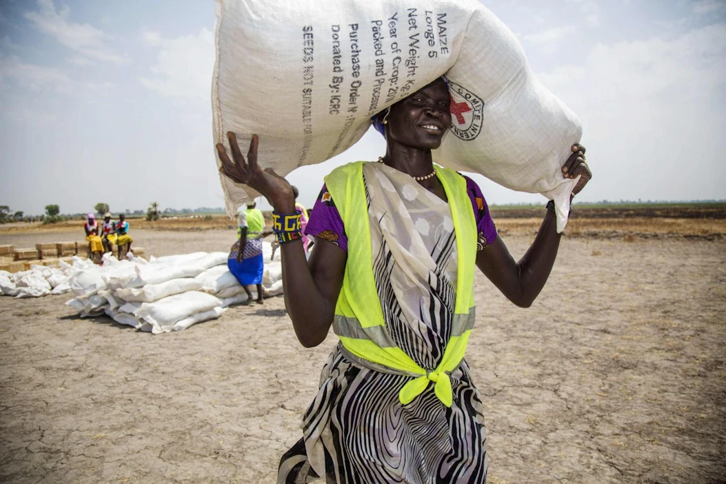 WFP:n pääjohtajan mukaan yli 30 maata on vaarassa luisua nälänhätään. Kuvassa Punaisen Ristin paikallisyhteisön vapaaehtoinen kantaa siemensäkkiä Etelä-Sudanissa, jonka väestöstä yli puolet kärsii ruokakriisistä. LEHTIKUVA/AFP