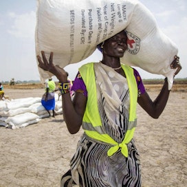 WFP:n pääjohtajan mukaan yli 30 maata on vaarassa luisua nälänhätään. Kuvassa Punaisen Ristin paikallisyhteisön vapaaehtoinen kantaa siemensäkkiä Etelä-Sudanissa, jonka väestöstä yli puolet kärsii ruokakriisistä. LEHTIKUVA/AFP