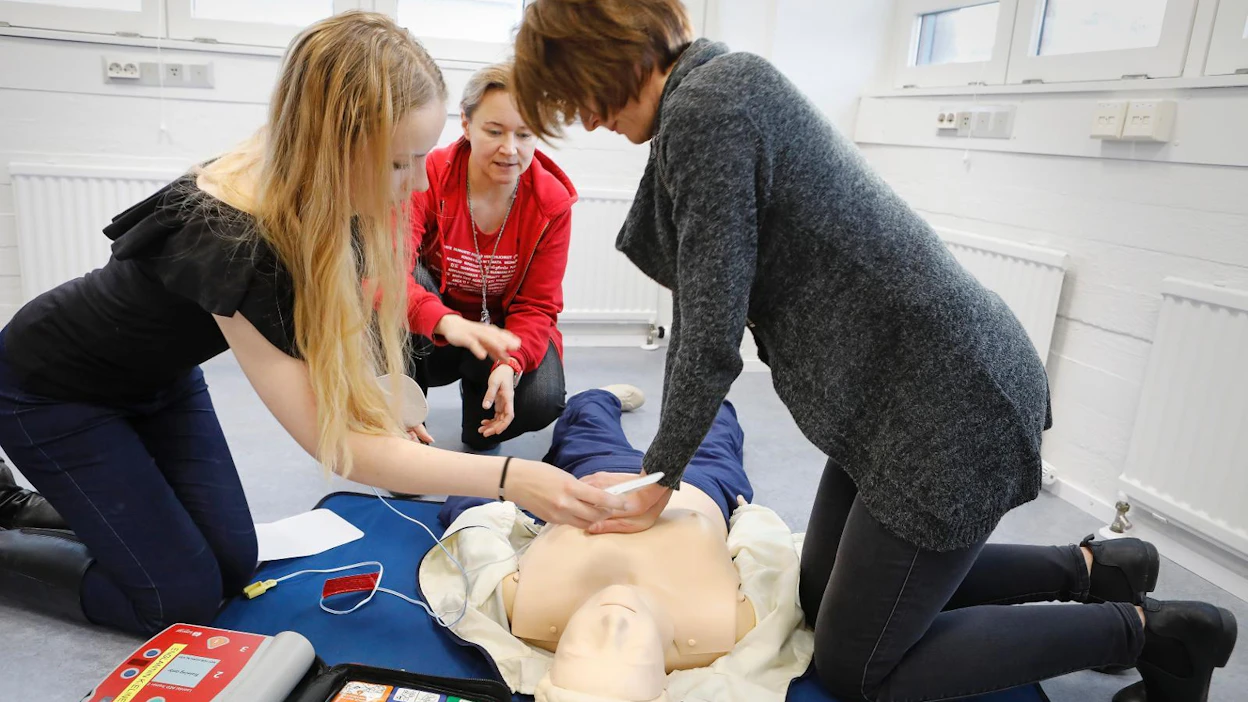 SPR on opettanut defibrillaattorin käyttöä ensiapukursseillaan vuodesta 2010 lähtien. Nina Rossi valvoo, kun Tea Selin asettaa sydäniskurin elektrodit paikalleen Eveliina Ishiin elvyttäessä nukkea.