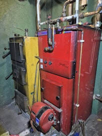 Vanha puukattila ja öljykattila sulassa sovussa. Huippukuormia tasaavan öljykattilan poispurkamisesta maksetaan tuhansien eurojen romutusraha, jos sen tilalle tulee sähköön pohjaava lämmitysjärjestelmä.