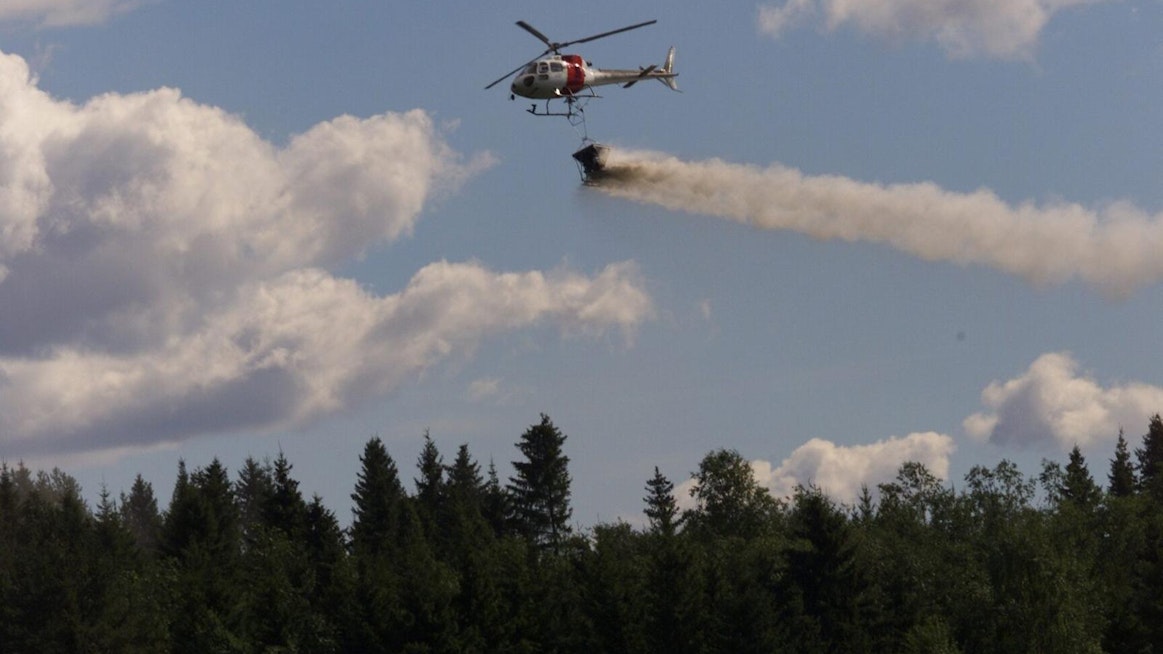 Pilotti levittää helikopterilla neulasanalyysin perusteella valmistettua puuston terveyslannoitetta.