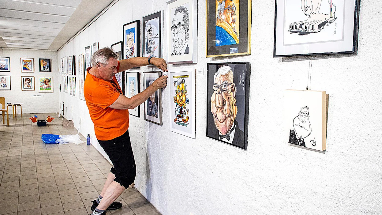 Juha S. Kalliolahti kiinnitti nimikylttinsä Kalervo Kummola -karikatyyrinsä yhteyteen Naantalin Taidehuoneen näyttelyssä.