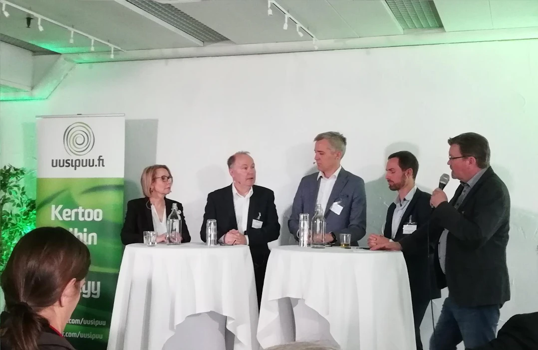 Uusi puu -tilaisuuden paneelikeskustelun asiantuntijat Liisa Mäkijärvi (vas.), Risto Huhta-Koivisto, Anders Adlercreutz ja Ernesto Hartikainen ovat yhtä mieltä siitä, että Suomen avain menestykseen on panostaminen puutuotteiden jalostusasteen nostamiseen. Tilaisuuden juonsi Jukka Relander (oik.).