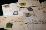 Ensimmäiset ehiöt eli kirjeet, joihin oli painettu valmiiksi maksuarvo, otettiin Suomessa käyttöön kolmantena maailmassa vuonna 1845. Kuvassa on vanhoja postimerkkiä ja -kuoria, jollaisia on esillä Joensuun pääkirjastossa tällä viikolla.