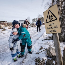 Veljekset Rainer (vas.) ja Raimo Lindholm seurailevat taustalla, kun Raimon pojat Juho ja Aleksi leikkivät aurinkoisena talvipäivänä kylätiellä.