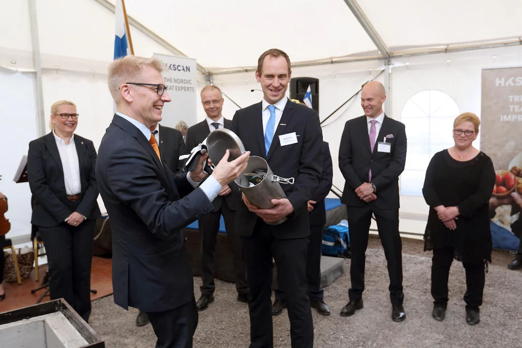 Ministeri Kimmo Tiilikainen sujautti tehtaan sisuksiin muurattavaan metallilieriöön maanantain Maaseudun Tulevaisuuden ja Helsingin Sanomat.