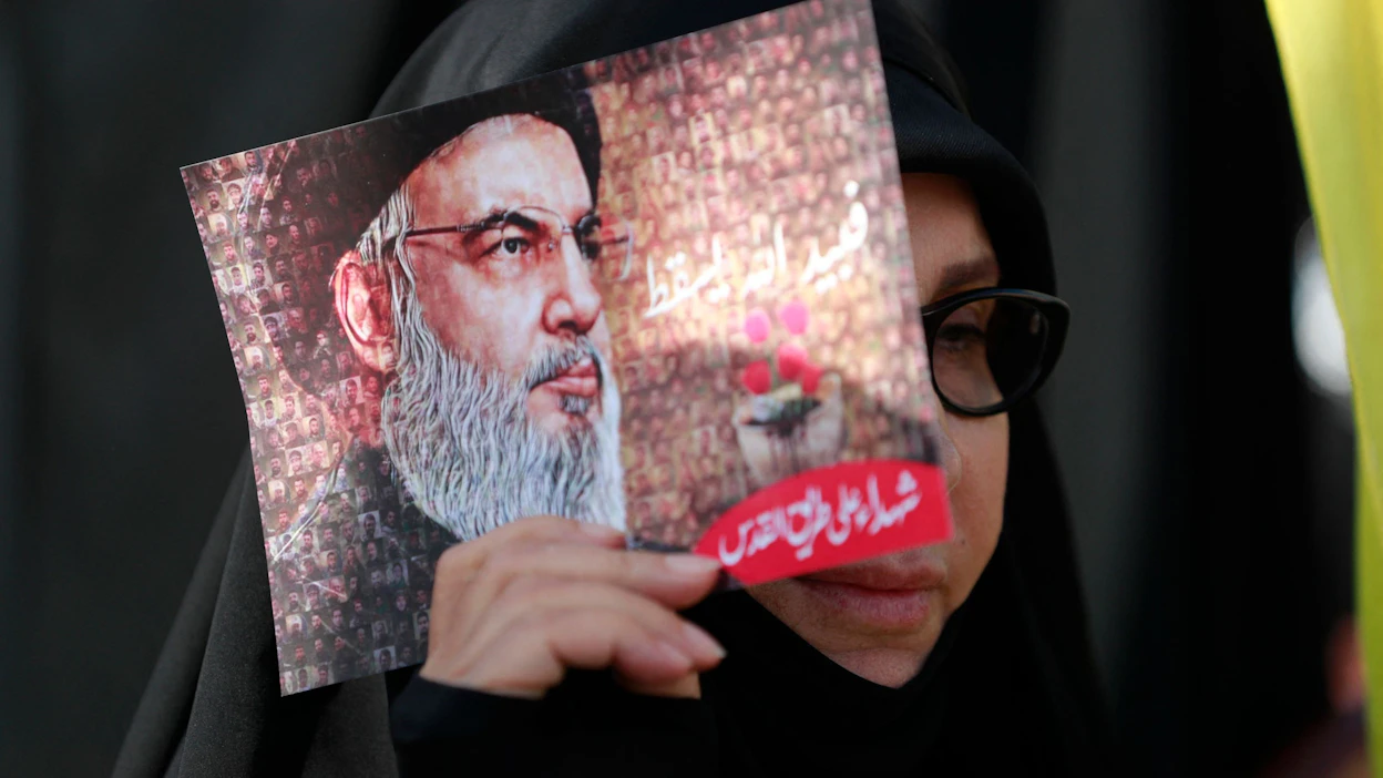 Hizbollah-johtaja Hassan Nasrallah esiintyi julkisuudessa ensimmäistä kertaa sen jälkeen, kun äärijärjestö Hamas hyökkäsi Israeliin vajaa kuukausi sitten. Nainen piteli Nasrallahin kuvaa perjantaina kokoontumisessa Beirutissa. LEHTIKUVA / AFP.