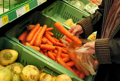 Sokos, S-Market. Porkkanaa, lanttua, ruukkusalaatit, ruukkuyrtit. Asiakas (Maija Päivärinta) ostamassa kotimaisia juureksia. Joutsenlippumerkki ruukkusalaatin pakkauksessa. Kotimaisia juureksia, salaatteja ja yrttejä.