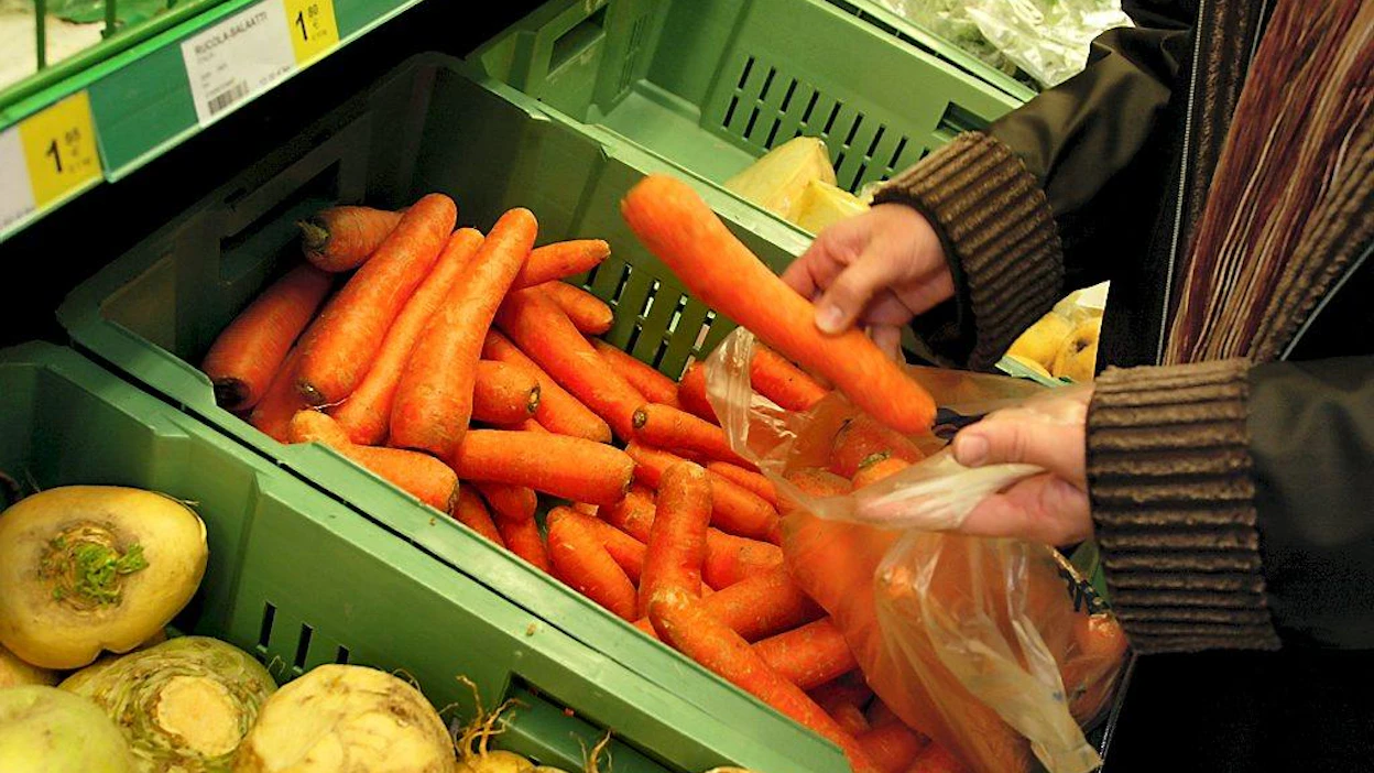Sokos, S-Market. Porkkanaa, lanttua, ruukkusalaatit, ruukkuyrtit. Asiakas (Maija Päivärinta) ostamassa kotimaisia juureksia. Joutsenlippumerkki ruukkusalaatin pakkauksessa. Kotimaisia juureksia, salaatteja ja yrttejä.