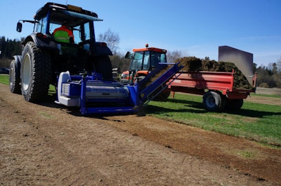 Tässä uusitaan Sipoon Massbyn pallokenttää. Valtran hytissä Jorma Nikolajew ja Kubotaa ajaa Teemu Häkkinen – molemman NH-koneen spesialisteja. Jyrsimisen yhteydessä pintaa myös tasoitetaan. Poistettava humuspitoinen aines on kysyttyä tavaraa läheistön puutarhaviljelijöille.