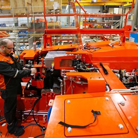 Sandvikin Turun-tehtaan asentajan  Jarno Hauhian (oik.)  oranssin väriset kaivosajoneuvot  myydään kaivoksiin eri puolille maailmaa.