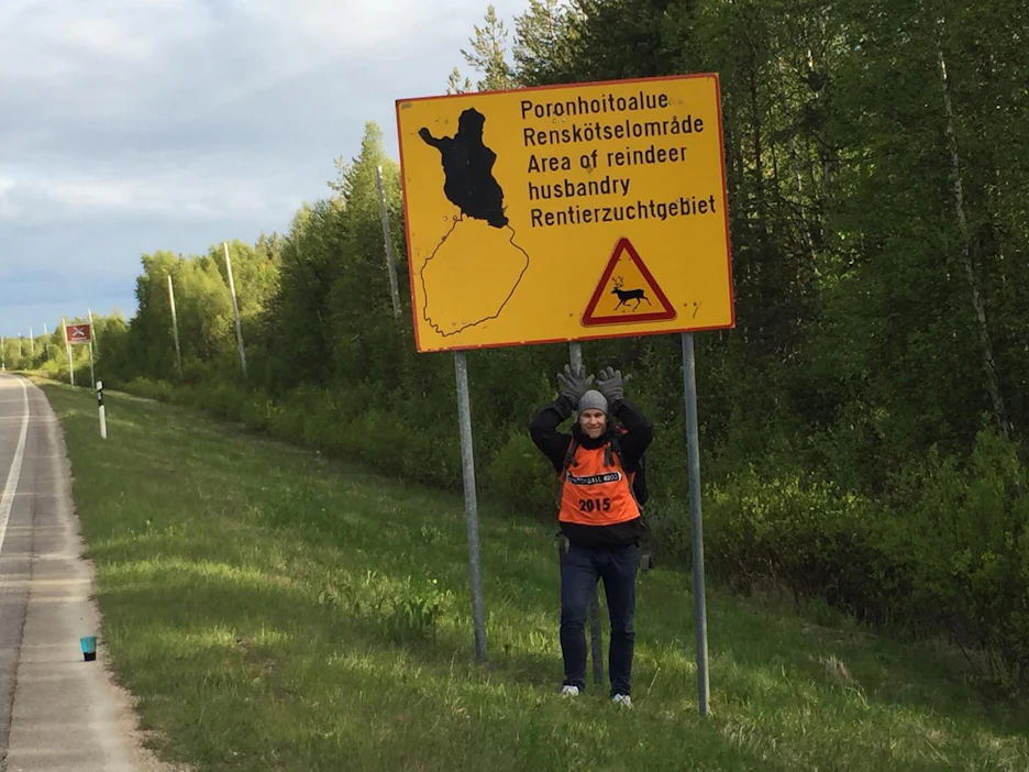 Olli Rissanen tuulettaa iloisena päästyään Lappiin. Tien päällä olevat Hitchball 4000 -kilpailijat erottaa keltaisista liiveistä. Kuva on otettu viime kesänä.