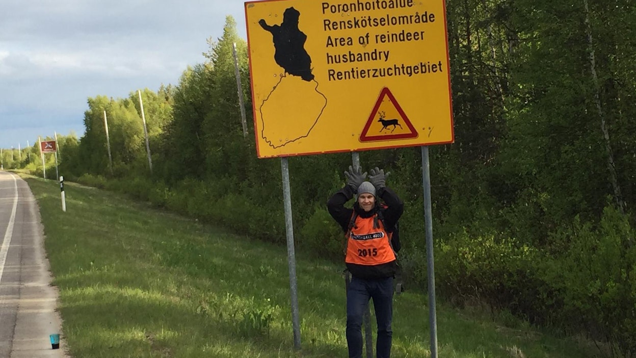 Olli Rissanen tuulettaa iloisena päästyään Lappiin. Tien päällä olevat Hitchball 4000 -kilpailijat erottaa keltaisista liiveistä. Kuva on otettu viime kesänä.