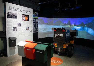 Postimuseon näyttelyssä kävijä pääsee hyppäämään jyväskyläläisen varhaisjakelijan kierrokselle talviaamun hämärään istahtamalla moposkootterin päälle.
