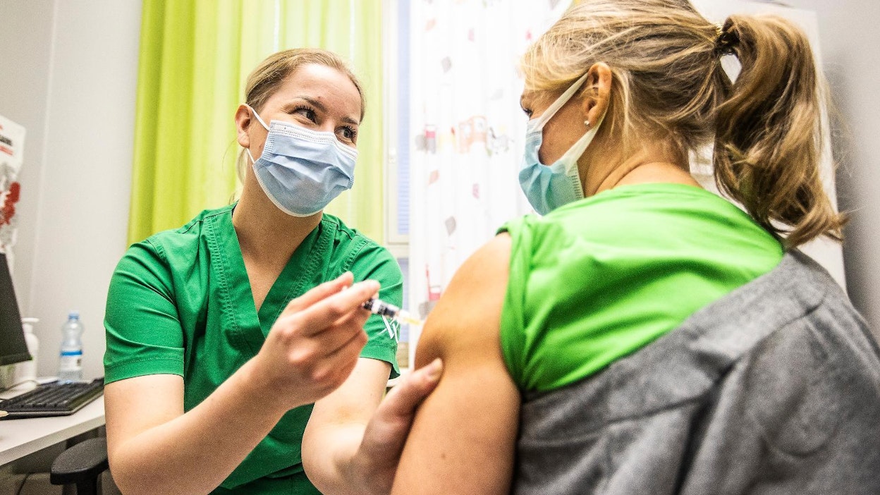 Sairaanhoitaja Meri Lavia antaa kausi-influenssarokotteen Carita Mitznerille lääkärikeskus Mehiläisessä.