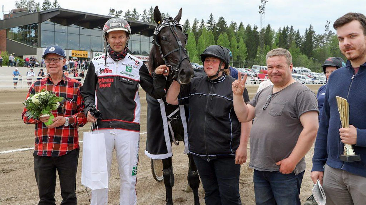 Hotshot Lucan ja voitonmerkkiä näyttävän Aripekka Pakkasen tiet ovat jälleen kohdanneet. Kuvassa hevosen ympärillä myös Pentti ja Kalevi Pietilä omistajaperheestä, hoitaja Marika Salin ja ohjastaja Mika Forss.