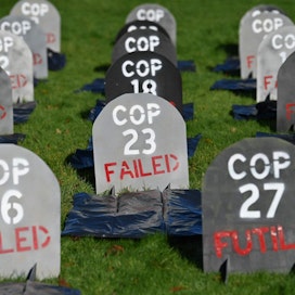 Glasgow&apos;n ilmastokokouksen tuloksia kritisoitiin esimerkiksi paikalliselle hautausmaalle pystytetyissä, hautakiviä muistuttavissa kylteissä. LEHTIKUVA / AFP