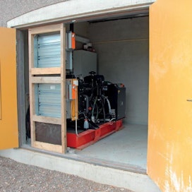 Generaattori on sijoitettu omaan tilaansa rakennuksen ulkoseinustalle. Huolto ja tankkaus on helppoa suuren oviaukon ansiosta. Vasemmanpuoleisen oven aukkojen läpi tapahtuu generaattorin ilmanvaihto.