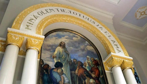 Lopen kirkon alttaritaulu, joka kuvaa Jeesusta puhumassa ihmisille. Alttaritaulun yläosa on koristeltu kultaisin kuvioin ja tekstein.