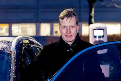 Vaaleatukkainen mies katsoo kohti kameraa. Taustalla näkyy pimeä parkkipaikka.