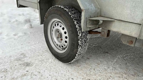 Perävaunun nastarengas lumisessa ympäristössä.