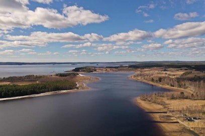 Nuasjärvi ilmasta kuvattuna, maisemassa näkyy saari, rantametsää ja taustalla jäven selkä.