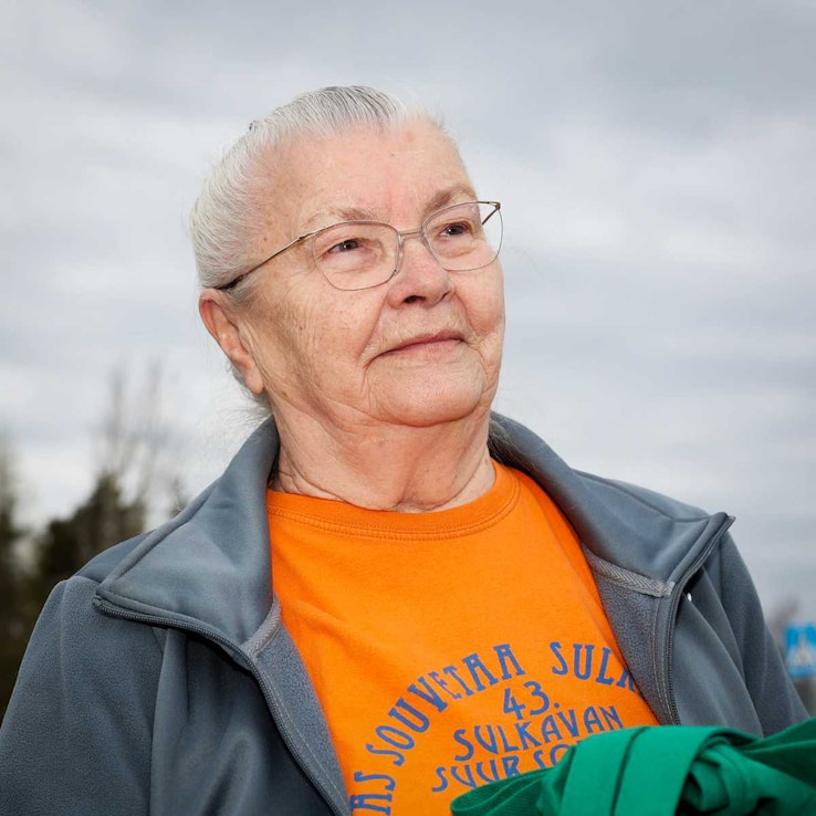 Lähikuva Kaija Saaraisesta oranssi paita yllään.